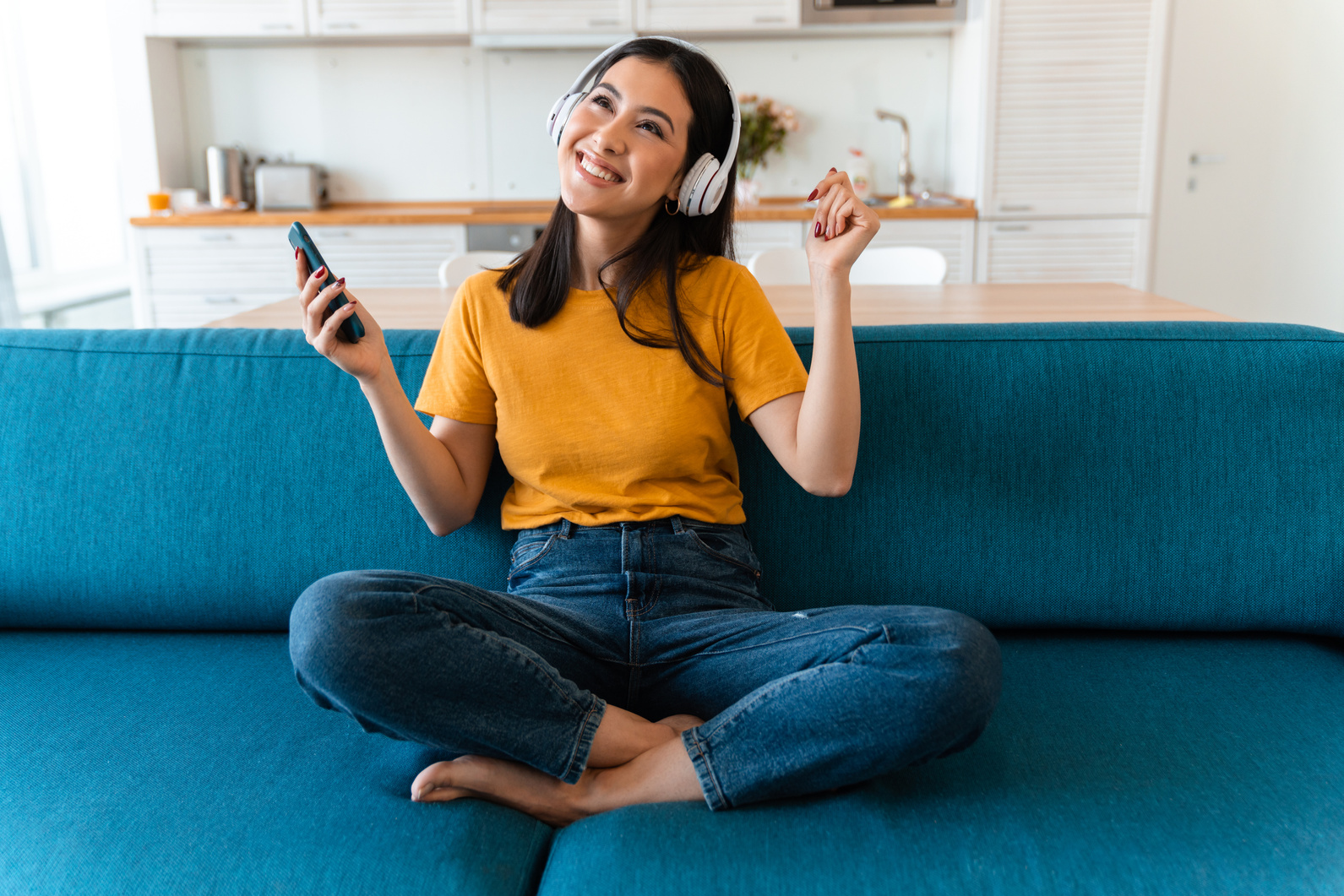 Happy Woman Listening Music Sitting on Sofa